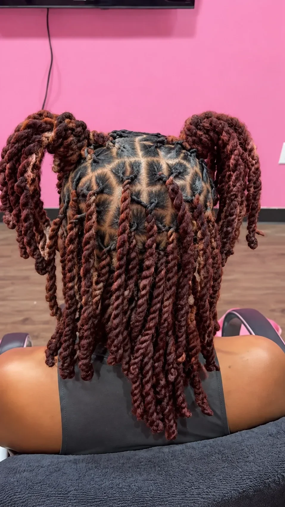 Finished burgundy rope twists gathered into two ponytails